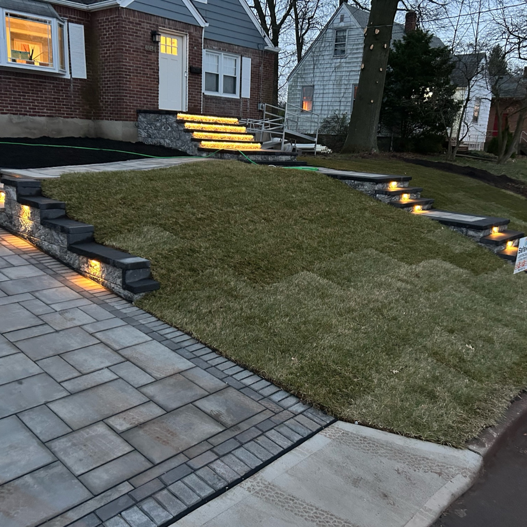 Front yard with custom pathway lighting and illuminated steps by Safe Way Outdoor Services